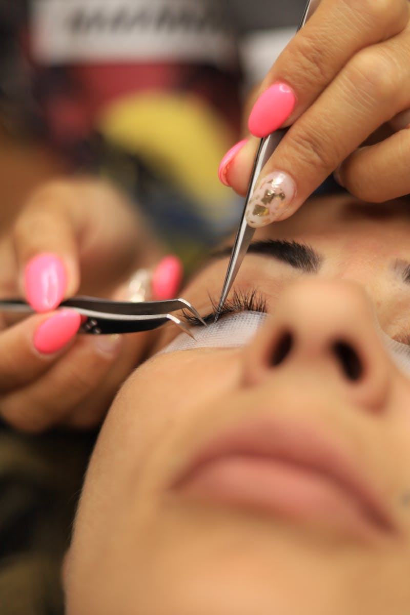 Woman performing eyelash extension maintenance with a clean spoolie